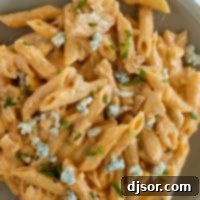 Ultimate Buffalo Chicken Pasta 10 Plate filled with buffalo chicken pasta topped with blue cheese.