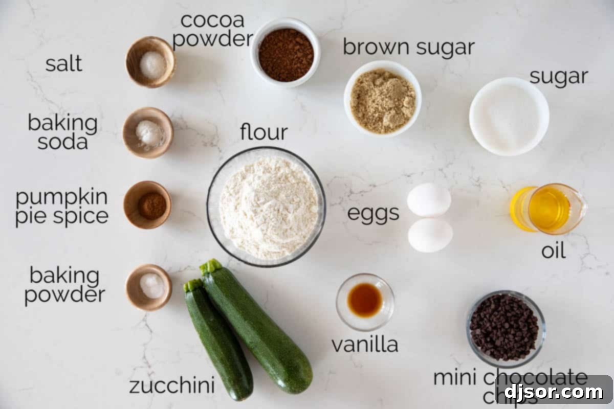 Essential Ingredients for Homemade Chocolate Zucchini Muffins A collection of fresh ingredients neatly laid out for preparing chocolate zucchini muffins, including eggs, sugar, oil, vanilla, flour, cocoa powder, spices, baking essentials, zucchini, and chocolate chips.