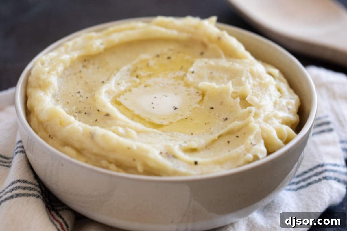 Perfectly Creamy Crockpot Mashed Potatoes 2 A large bowl filled with fluffy mashed potatoes, perfectly made in the crockpot, ready to be served.