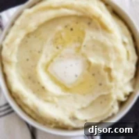 Perfectly Creamy Crockpot Mashed Potatoes 9 A bowl of Crockpot Mashed Potatoes topped with a pat of butter and pepper, visually appealing and ready to be enjoyed.
