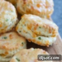Jalapeño Cheddar Biscuits stacked on a board.