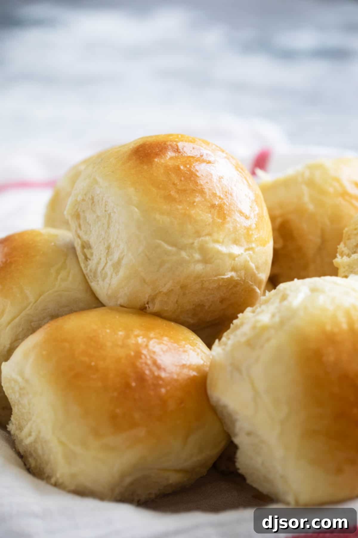 Freshly baked Brioche Rolls stacked in a rustic bowl, highlighting their soft texture.