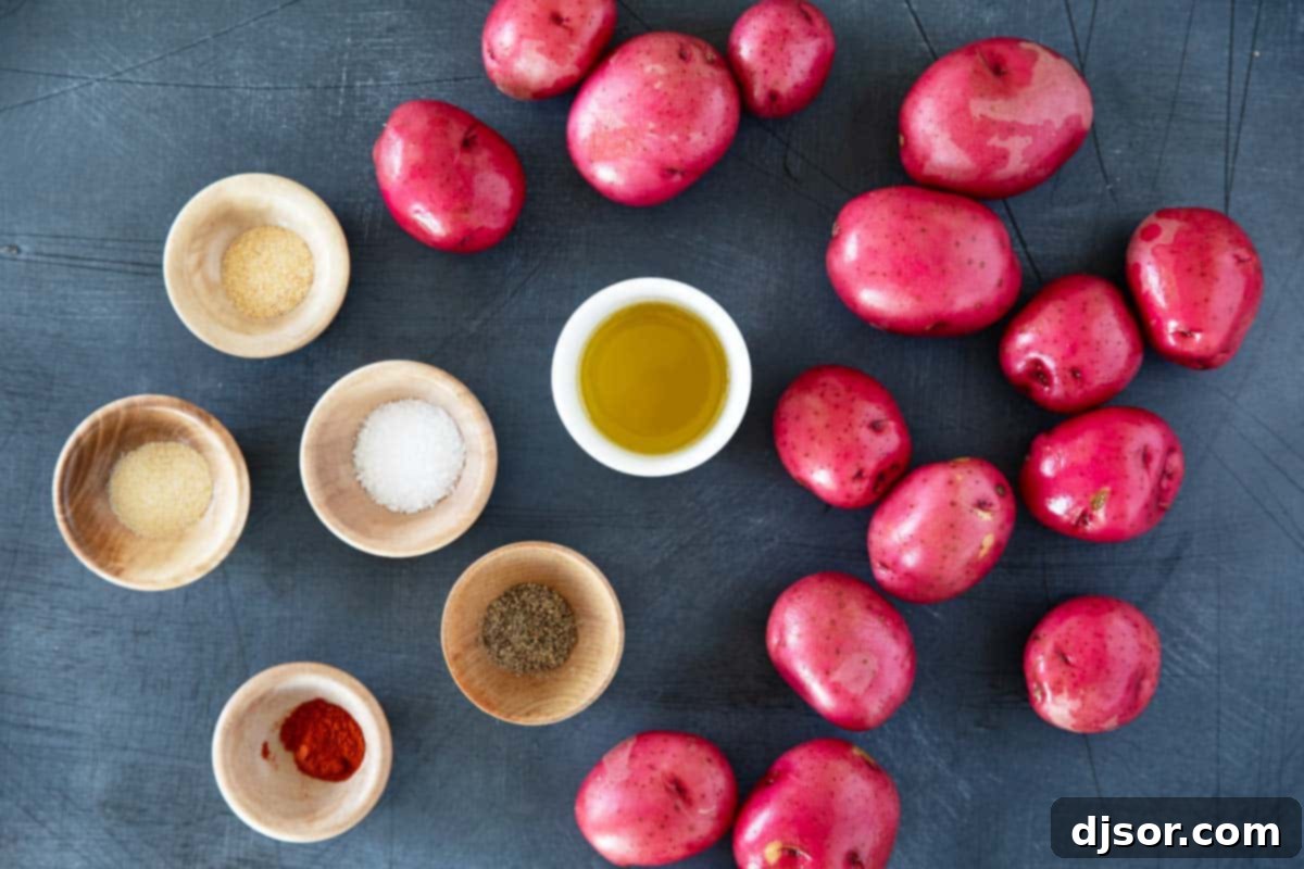 A bowl filled with diced raw potatoes, alongside small bowls of olive oil, salt, smoked paprika, garlic powder, onion powder, and black pepper, representing the ingredients for homemade breakfast potatoes.