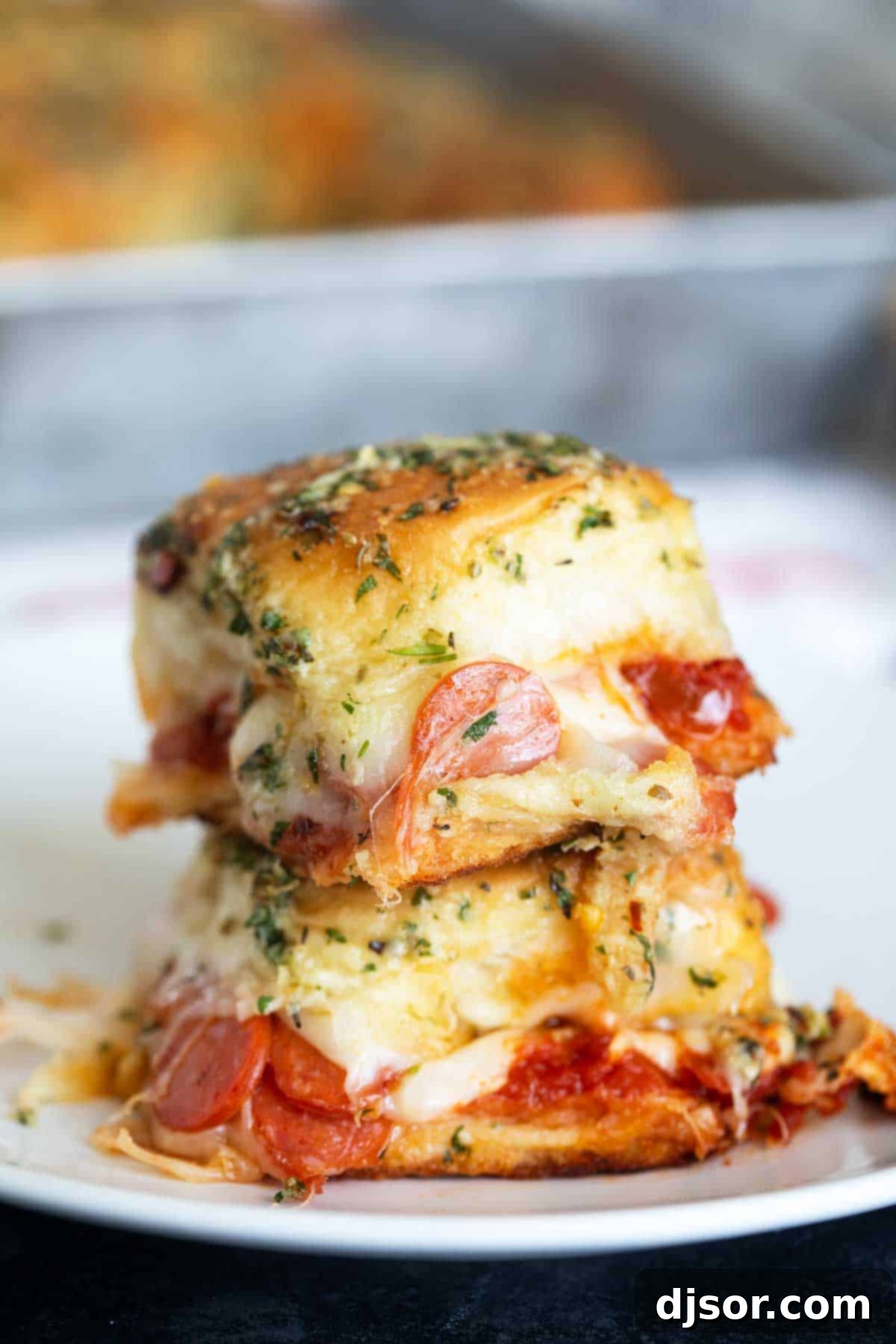 Pepperoni Pizza Poppers 2 Two pepperoni pizza sliders stacked on top of each other.