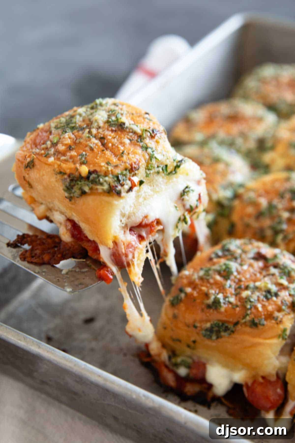 Pepperoni Pizza Poppers 8 Pulling a pepperoni pizza slider for the baking pan.