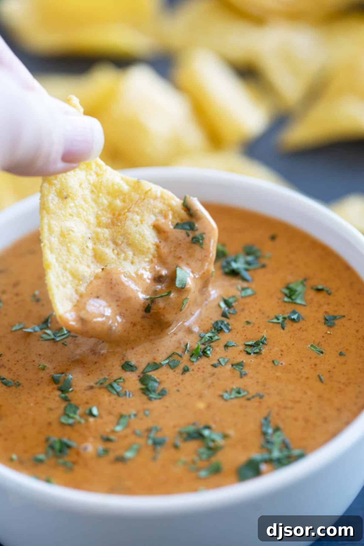 Dipping a chip into Chili's Queso Dip.