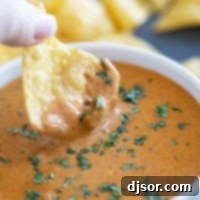 Dipping a chip into Chili's Queso Dip.
