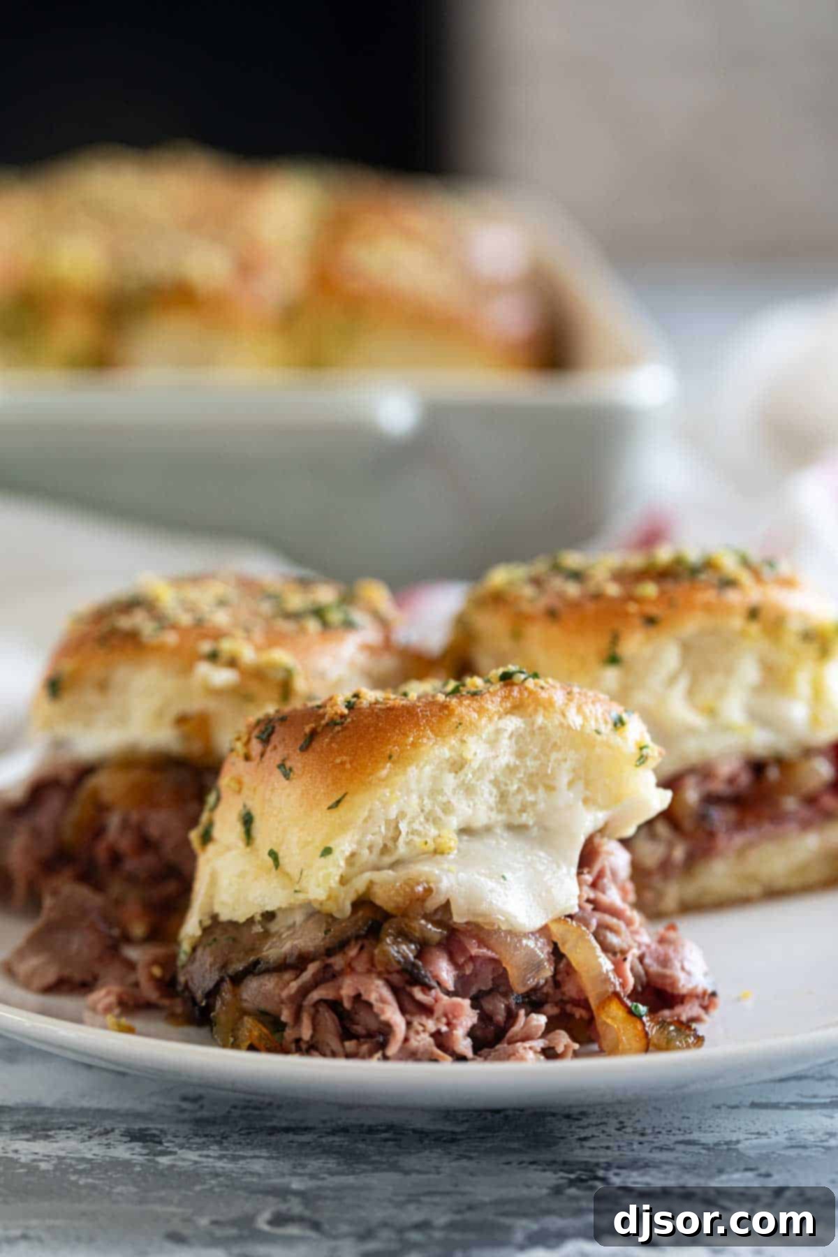 Roast Beef Sliders with caramelized onions on a plate.