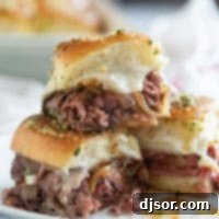 Three roast beef sliders, with one stacked on top of the others.