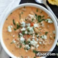 Fiery Buffalo Chicken Chili 8 White bowl filled with Buffalo Chicken Chili made with ground chicken, and topped with blue cheese and minced cilantro.