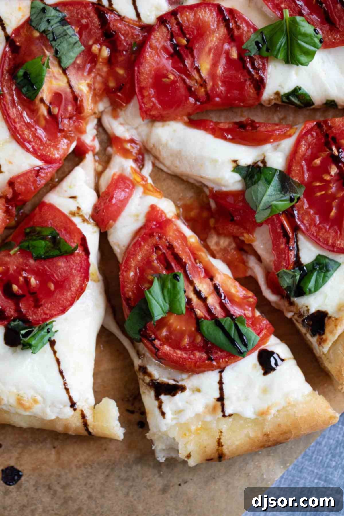 Slices of caprese pizza topped with balsamic glaze.