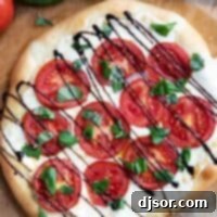 Caprese Pizza with mozzarella, tomatoes, basil, and balsamic glaze.
