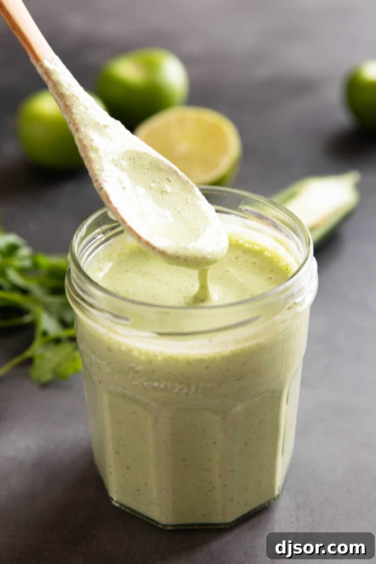 A spoon dripping with creamy Tomatillo Ranch Dressing, highlighting its smooth, rich texture and inviting taste.