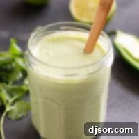 Tomatillo Ranch Dressing in a glass jar with a wooden spoon.