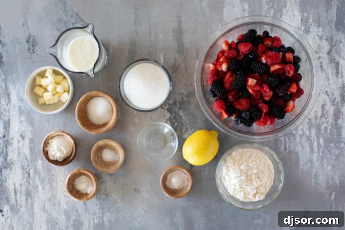 Assortment of fresh ingredients for Berry Cobbler, including mixed berries, sugar, flour, butter, and buttermilk, neatly arranged on a kitchen counter.