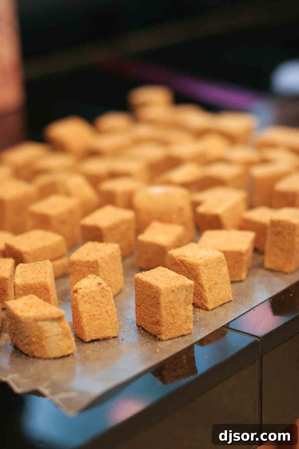 Soft and Fluffy Homemade Pumpkin Spice Marshmallows Freshly prepared pumpkin spice marshmallows artfully arranged on a sheet of wax paper, ready for cutting.
