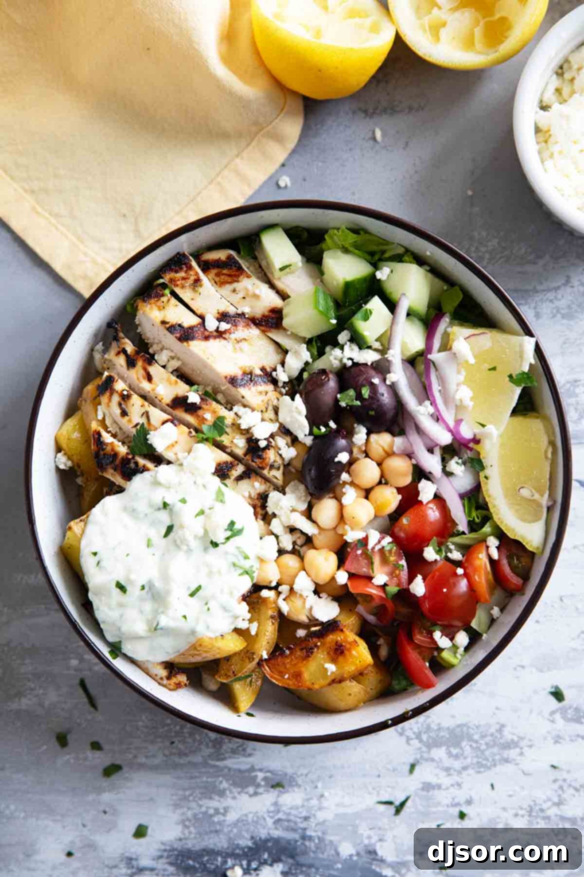 Greek Chicken Bowls with greek roasted potatoes, grilled chicken, and homemade tzatziki sauce.