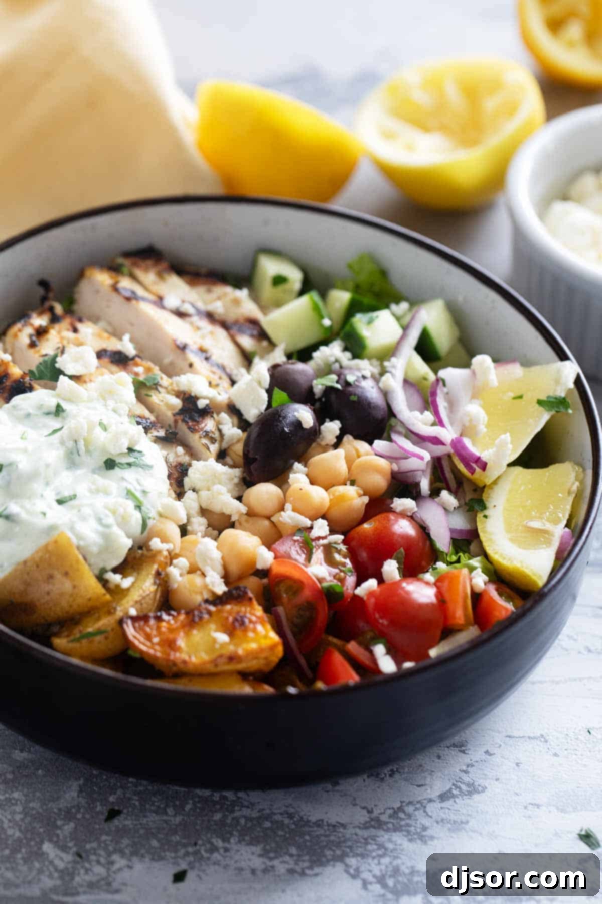 Greek Chicken Bowls with Greek roasted potatoes, grilled chicken, and lots of vegetables.