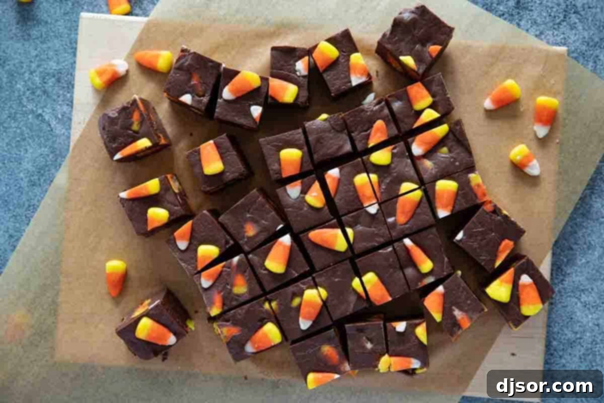 Perfectly sliced squares of homemade Candy Corn Fudge arranged on parchment paper, ready to be enjoyed as a festive fall dessert.