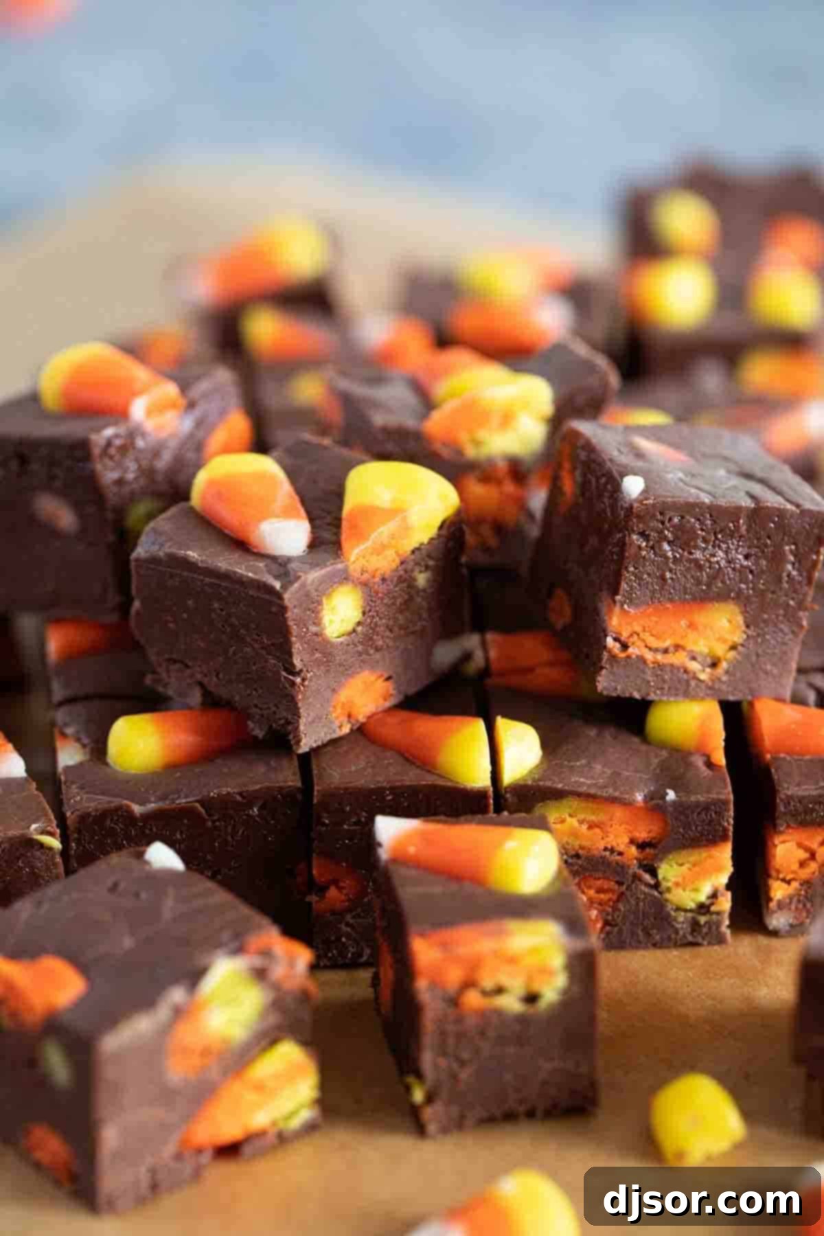 A charming stack of several squares of homemade Candy Corn Fudge, showcasing its rich texture and festive candy corn pieces.