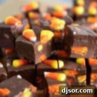 A beautifully arranged stack of Candy Corn Fudge squares, showing the creamy texture and festive candy pieces, ready to be served.
