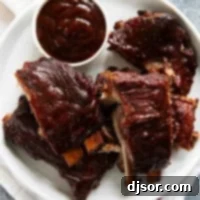 Plate full of bbq slow cooker ribs with a bowl of bbq sauce.