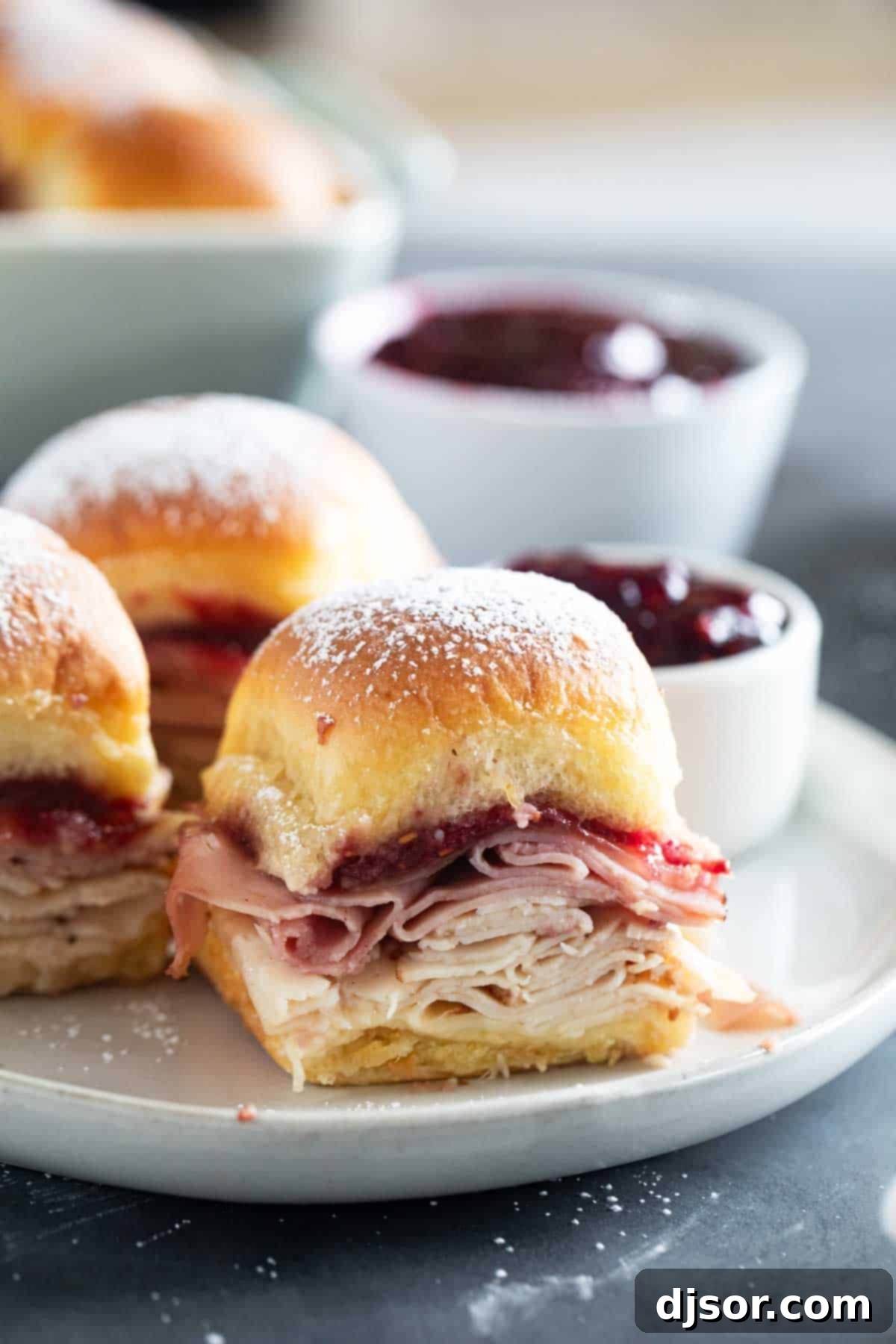 Sweet and Savory Monte Cristo Minis 2 Monte Cristo Sliders on a plate with raspberry jam for serving.