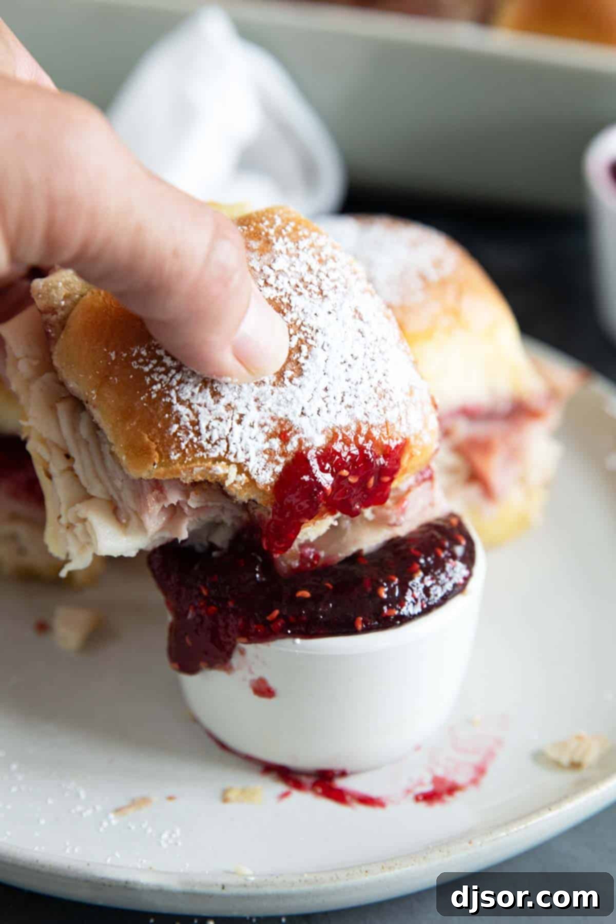 Sweet and Savory Monte Cristo Minis 7 Dipping a monte cristo slider into raspberry jam.
