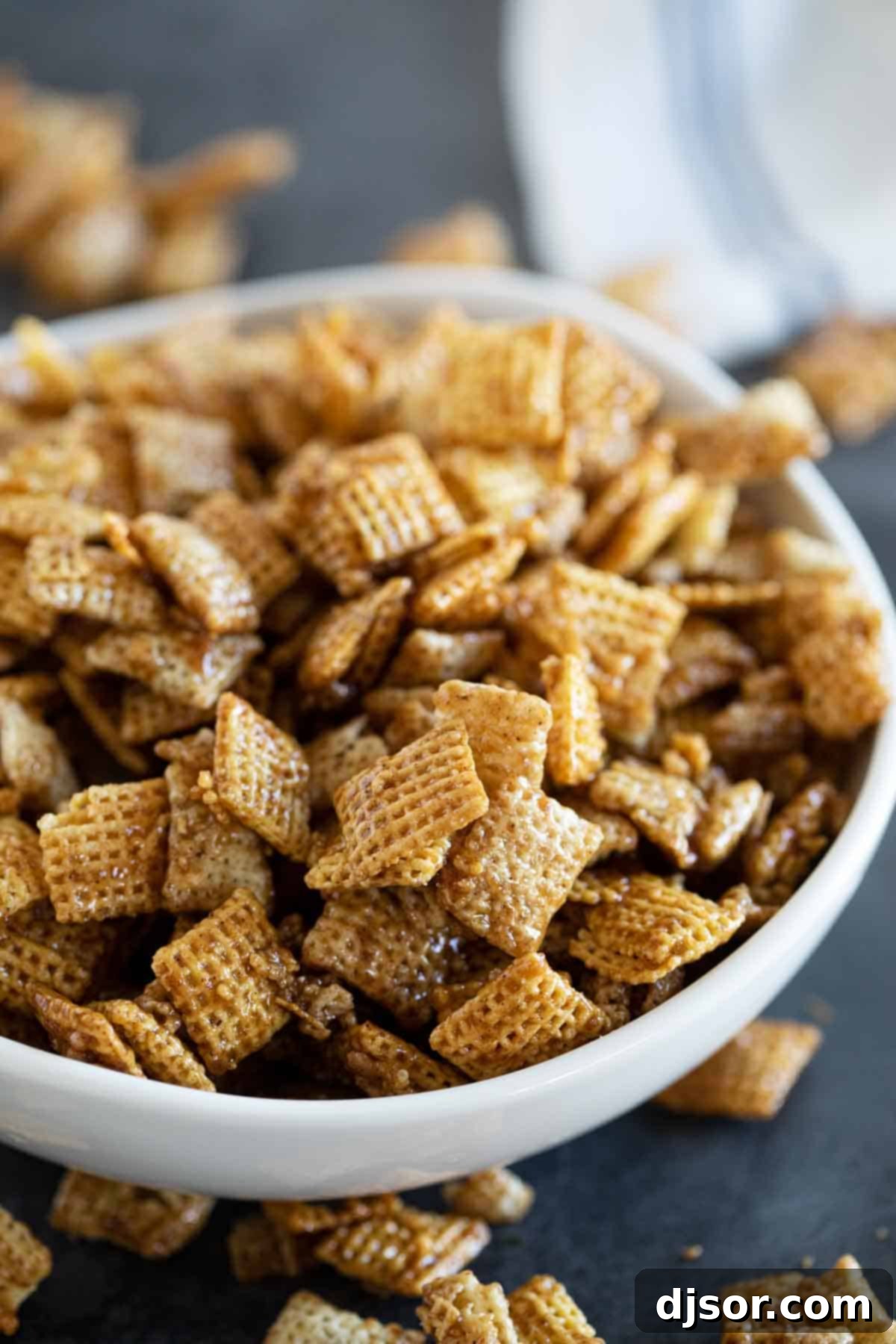 A large bowl overflowing with perfectly coated Cinnamon Caramel Snack Mix, highlighting its golden hue and delicious appeal.