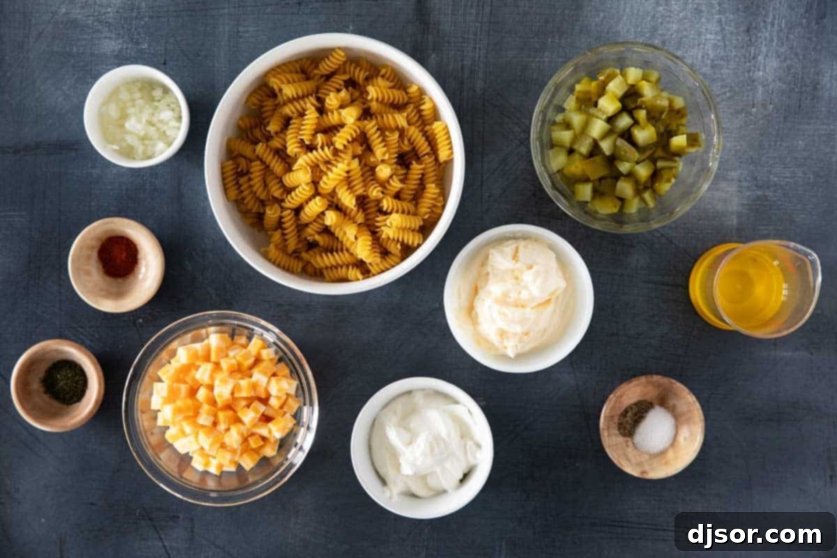 Briny Burst Pasta Salad 3 Collection of fresh ingredients for making Dill Pickle Pasta Salad, including pasta, mayonnaise, pickles, and cheese.