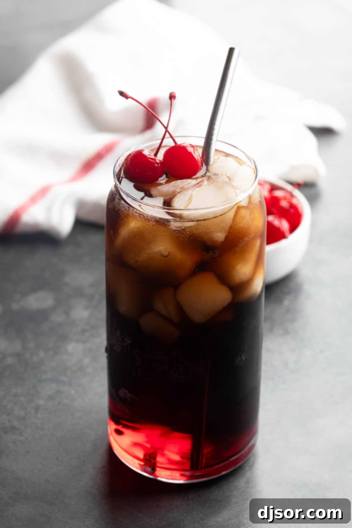 A vibrant Roy Rogers Drink with grenadine, cola, and bright red maraschino cherries, garnished for ultimate refreshment.