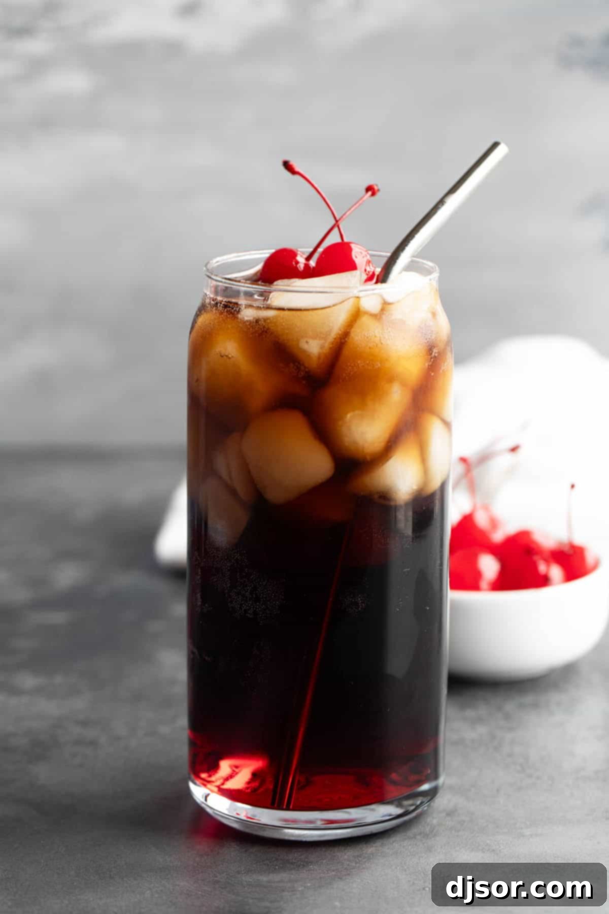 Roy Rogers Drink served in a tall glass with a reusable metal straw and maraschino cherries.