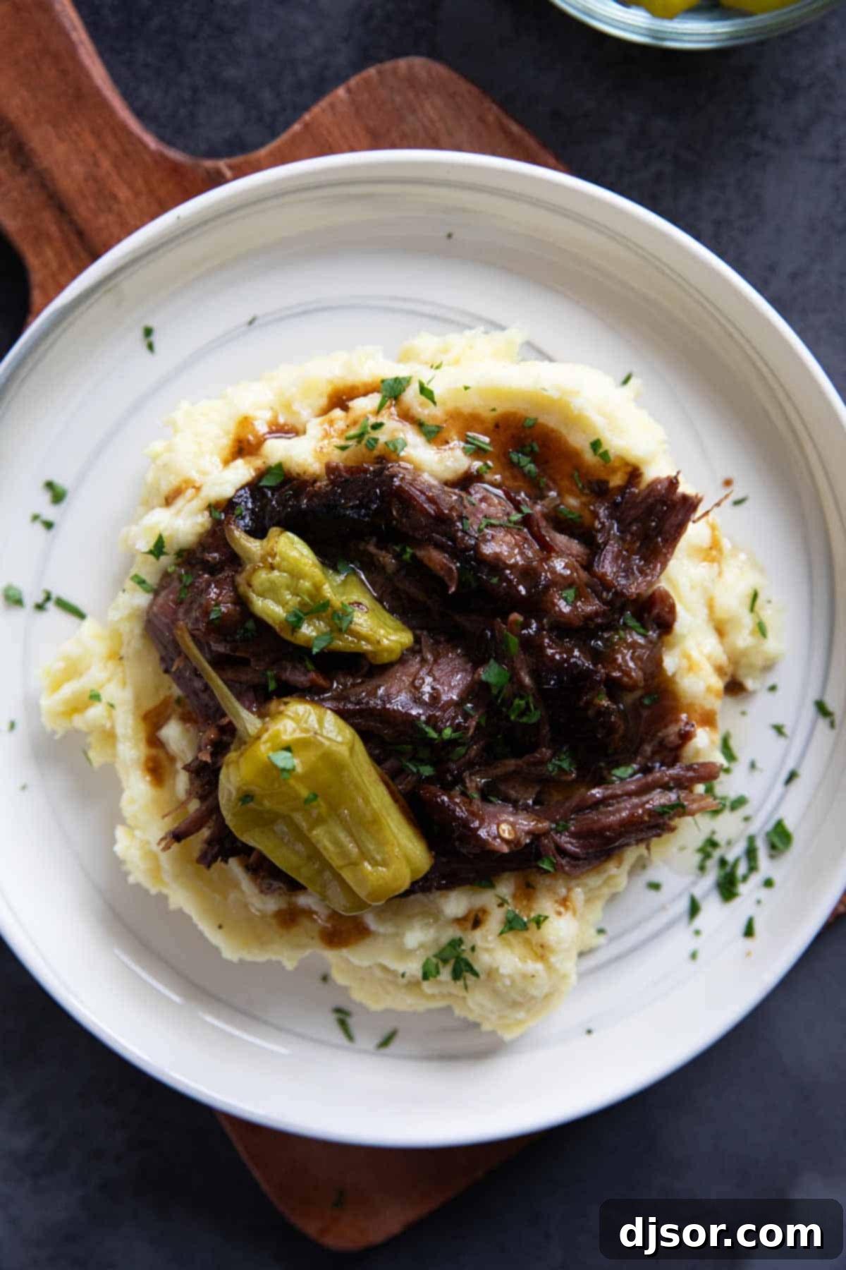 Mississippi Magic Pot Roast 5 Mississippi Pot Roast served with mashed potatoes, adorned with whole pepperoncini peppers.