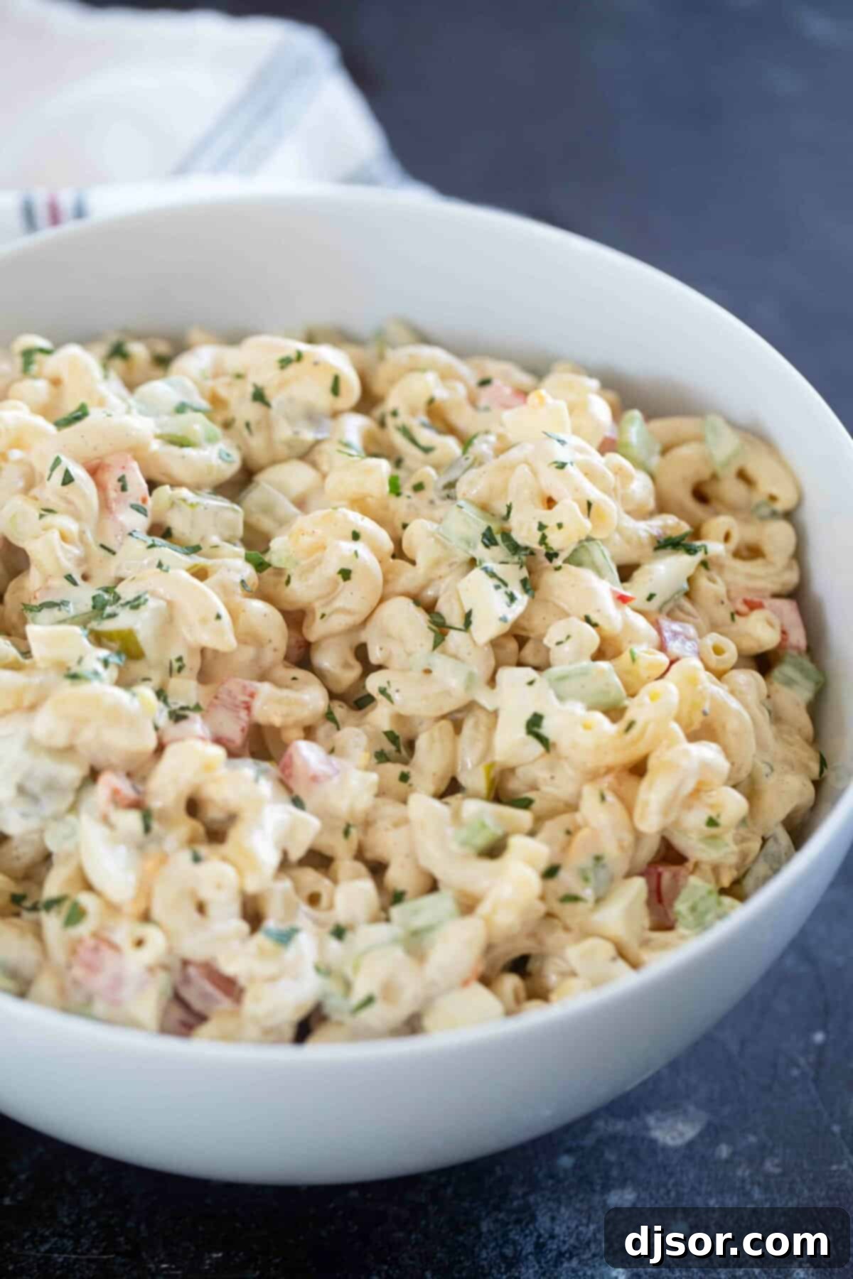 Creamy Macaroni Delight 2 Bowl filled with creamy macaroni salad featuring celery, bell peppers, hard-boiled eggs, and a rich dressing.