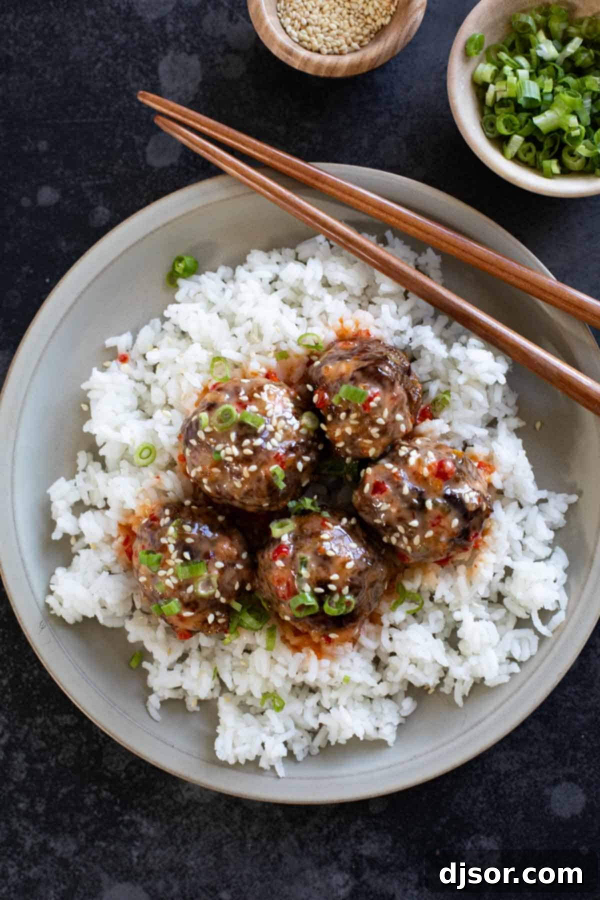 Firecracker Meatballs over rice on a plate.