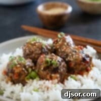 Firecracker Meatballs over rice, topped with green onions and sesame seeds.
