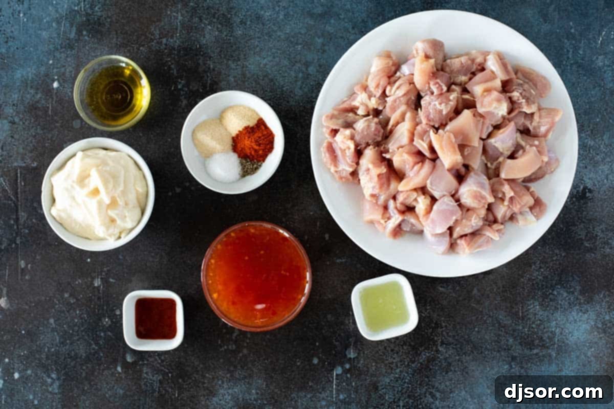 Ultimate Bang Bang Chicken Skewers 3 Various ingredients laid out to make Bang Bang Chicken Skewers, including chicken, spices, and sauce components.