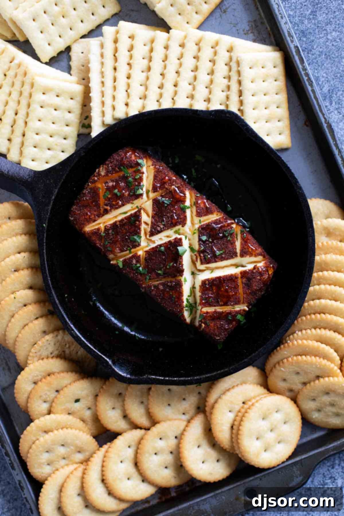 Smoked cream cheese in a cast iron dish, surrounded by crackers, ready to be served as an appetizer.