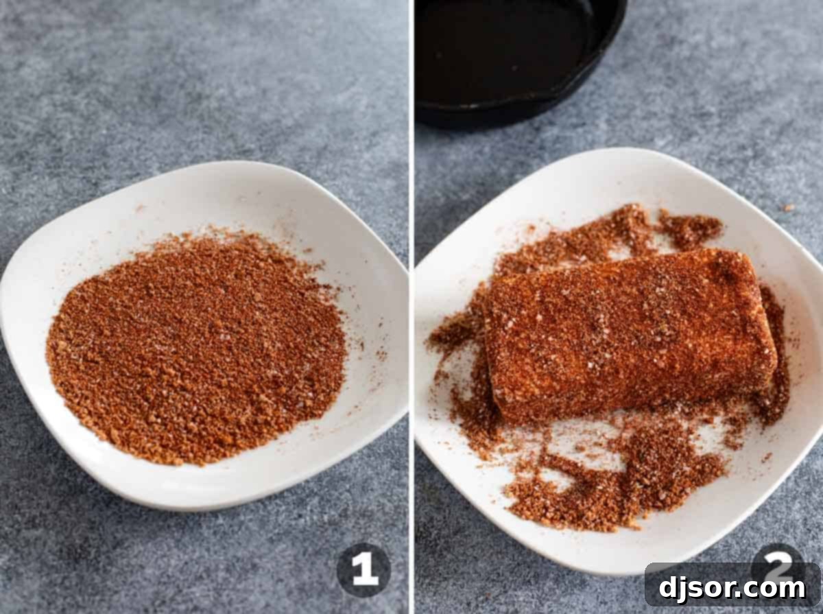 Applying a dry spice mixture to a block of cream cheese on a plate before smoking.