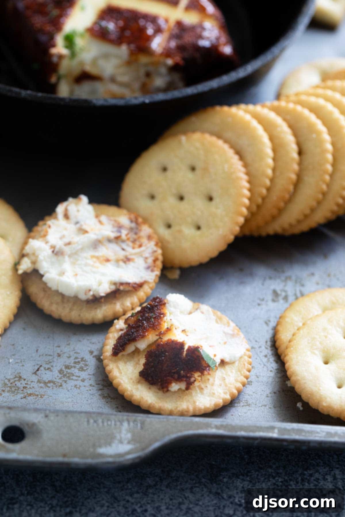 Delicious smoked cream cheese spread on crackers, showcasing its creamy texture and seasoned crust.