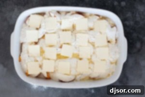 Adding butter to the top of peach dump cake.