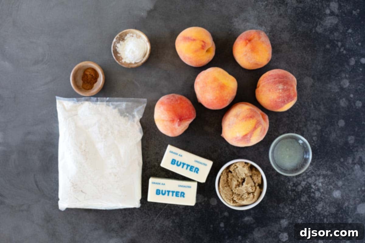 A collection of ingredients laid out on a table, including fresh peaches, brown sugar, cornstarch, lemon, spices, yellow cake mix, and butter, ready for making peach dump cake.