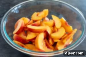 Sliced peaches in a large glass bowl.