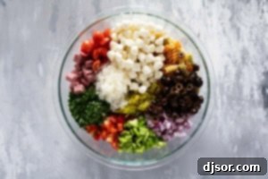 Adding Italian pasta salad ingredients to a bowl.