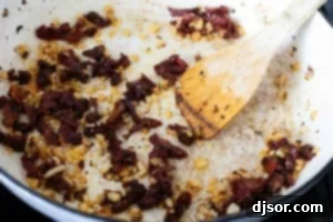 Sautéing onions and sun-dried tomatoes in a skillet.