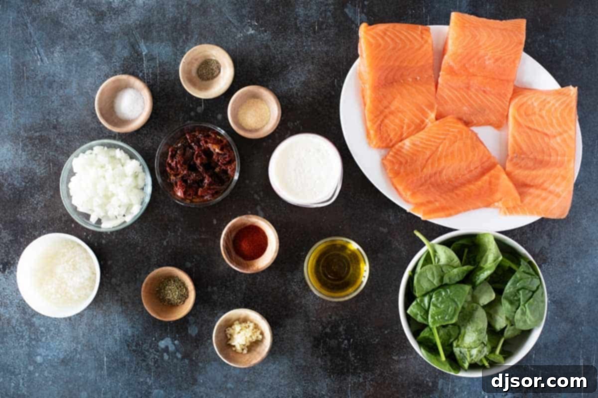 All fresh ingredients laid out for making Tuscan Salmon, including salmon fillets, spinach, sun-dried tomatoes, and cream.