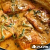 Tuscan Salmon in a skillet with sundried tomato cream sauce.
