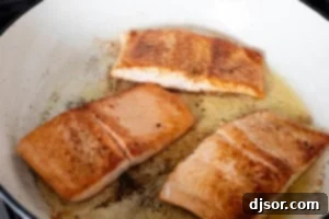 Cooking Tuscan Salmon in a skillet.