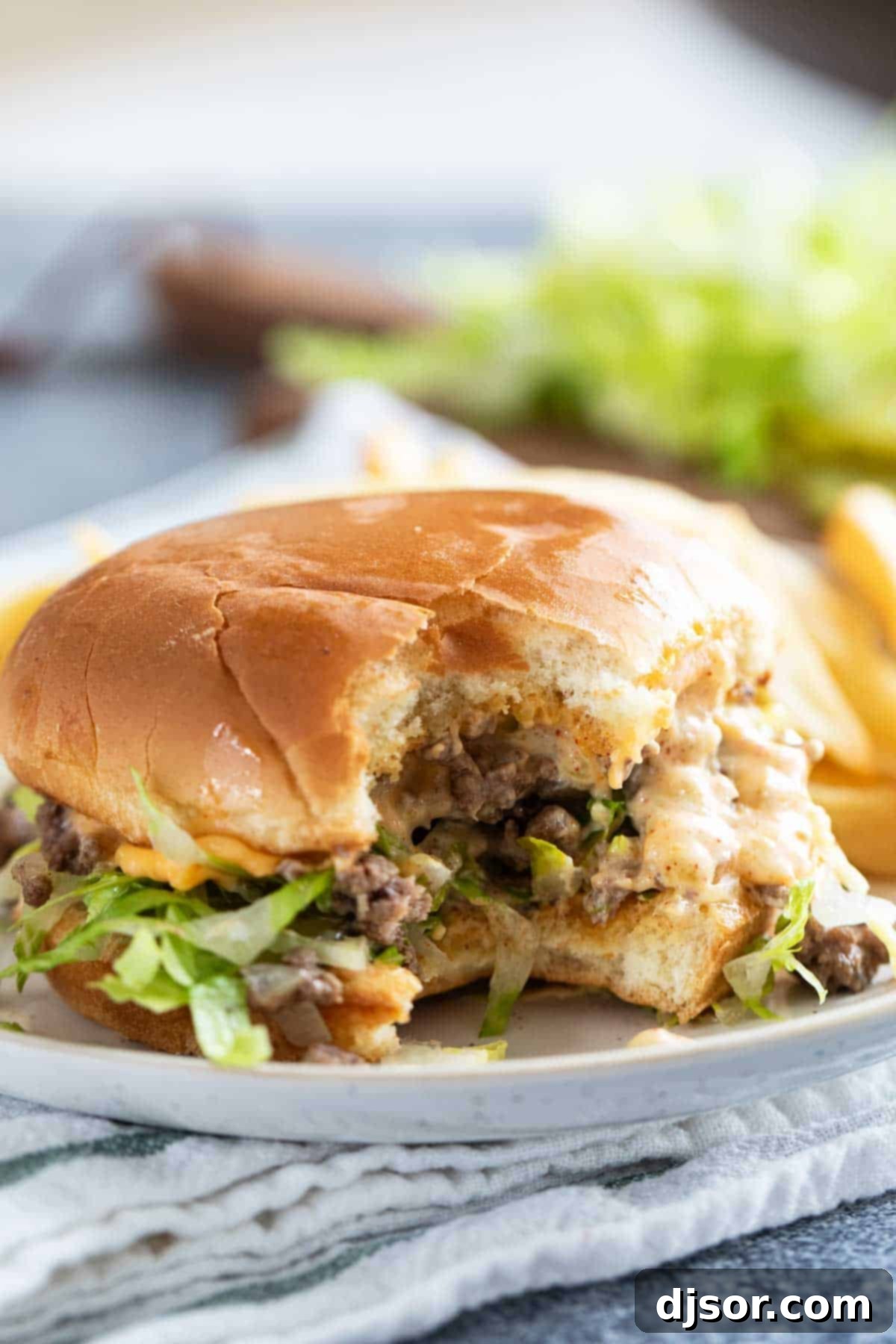 Big Mac Sloppy Joe with a bite taken from it on a plate.