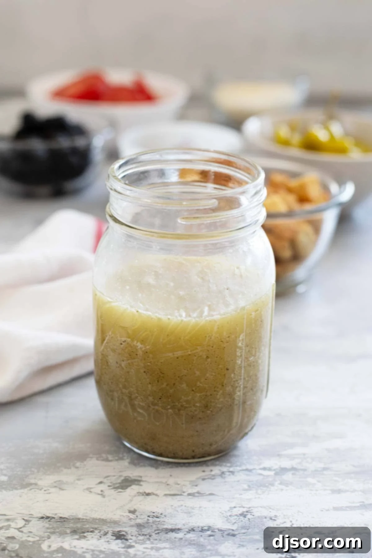 Homemade Olive Garden Salad Dressing in an elegant mason jar, ready to be served over a fresh salad, highlighting its rich, creamy texture.